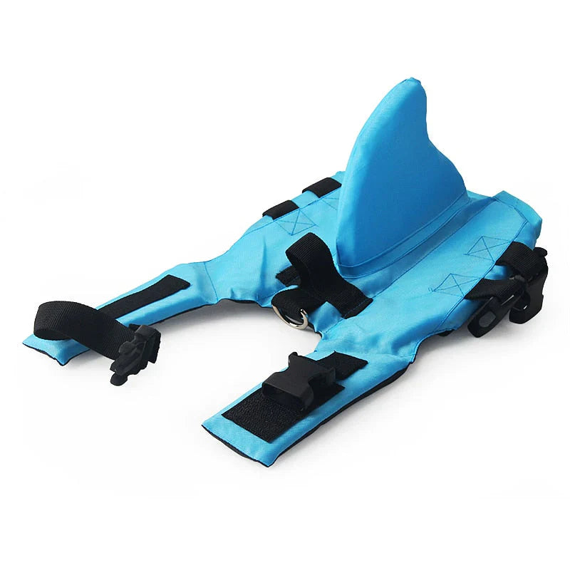Dog life jacket with shark fin, offering buoyancy and fun for all water activities; bright material, adjustable straps.