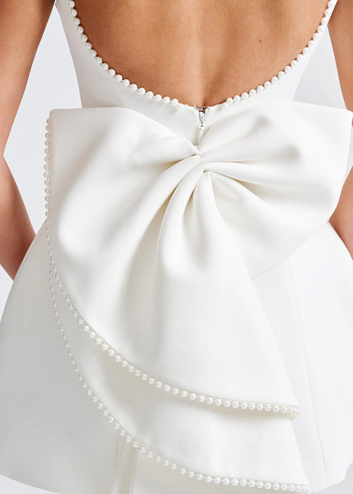 Elegant women's mini dress with pearl embellishments, structured fit, in black or white, ideal for evening events and occasio