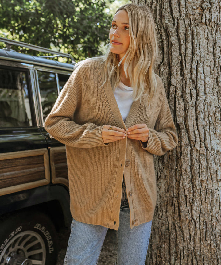 Front view of a soft, stylish women's cashmere cardigan in beige, showcasing its elegant, timeless silhouette for layering.
