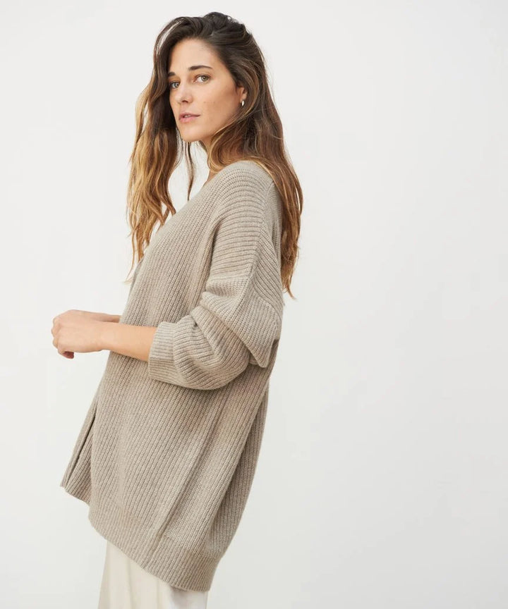 Front view of a soft, stylish women's cashmere cardigan in beige, showcasing its elegant, timeless silhouette for layering.