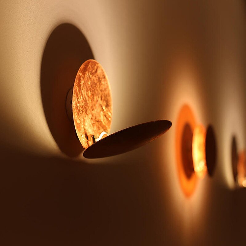 "Golden Solaris Wall Lamp with eclipse-inspired design, featuring elegant gold discs and warm LED glow for home decor."