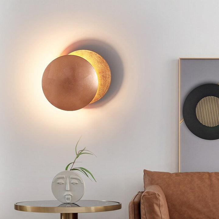 "Golden Solaris Wall Lamp with eclipse-inspired design, featuring elegant gold discs and warm LED glow for home decor."