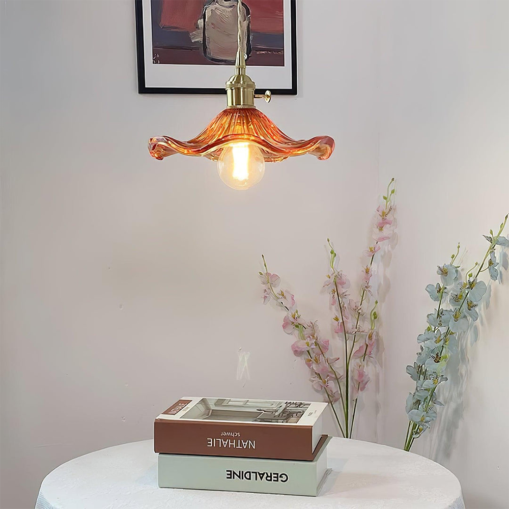 "Hibiscus flower-shaped pendant light in brass and glass, adds elegance and vibrancy to stylish room decor."