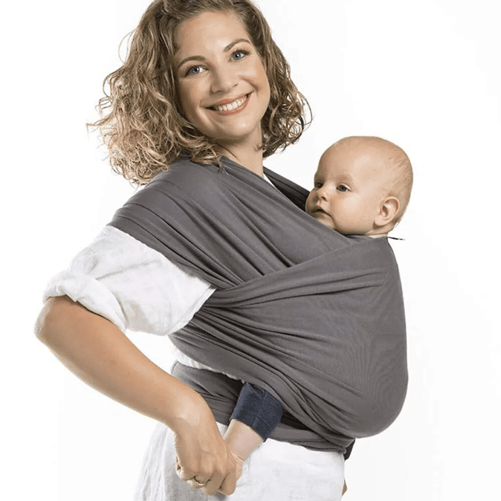 "Unisex ergonomic baby wrap carrier, grey, enveloping baby and parent comfortably for hands-free convenience."