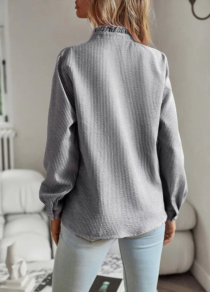 "Women's luxurious polo blouse, soft fabric with a classic button placket and tailored hem, perfect for elegant daily wear."