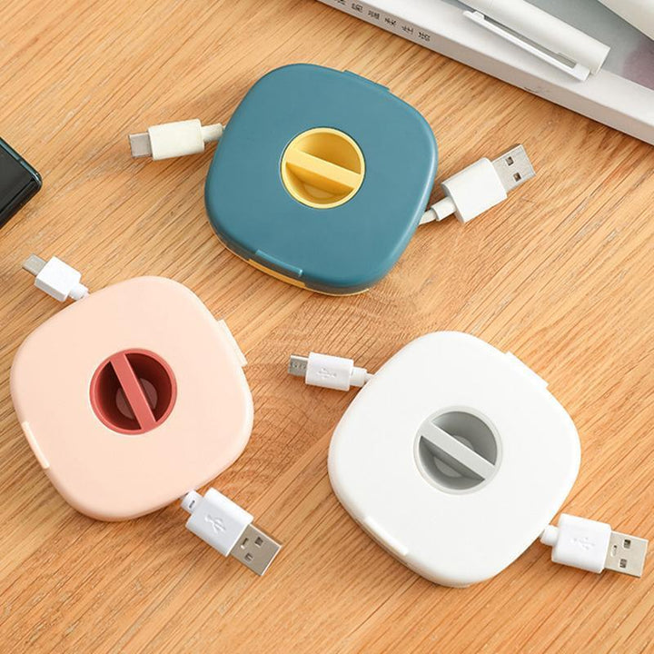 Pink universal cable winder and phone stand, displaying phone propped up, ideal for hands-free viewing.