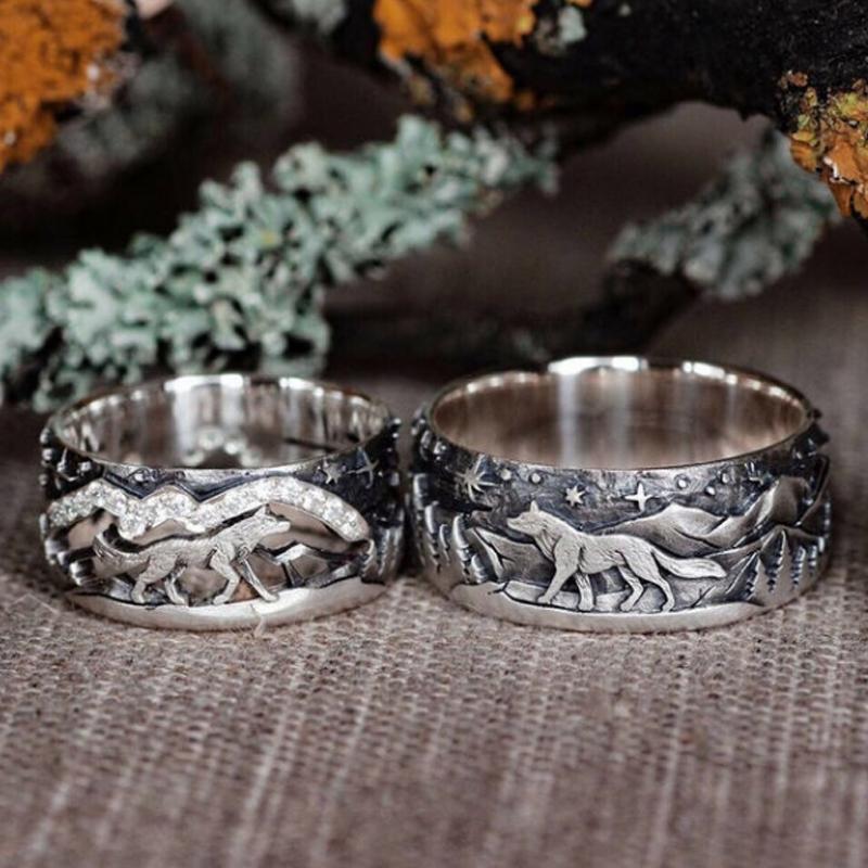 Close-up of a pair of unisex wolf rings, silver-toned, symbolizing loyalty and love. Perfect couple jewelry.
