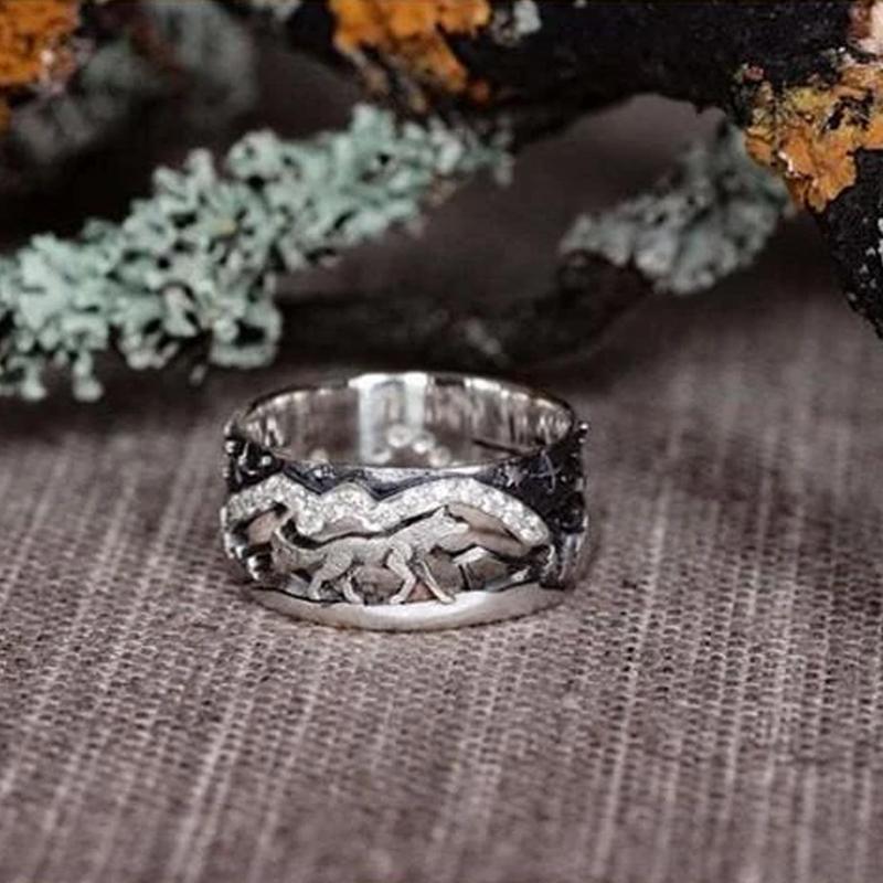 Two matching wolf head rings, crafted from metal with cubic zirconia eyes, representing an anniversary gift.