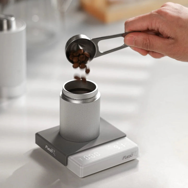 "Compact digital coffee scale with precise 0.1g measurement, black sleek design, clear LCD display for coffee brewing."