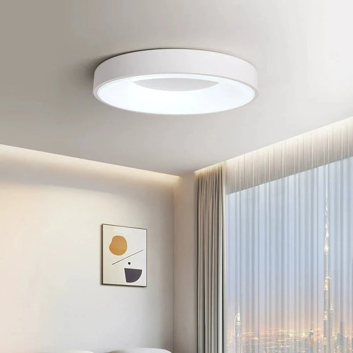 Contemporary circular metal LED ceiling light, sleek design with acrylic finish, emits soft warm or cool lighting for home de