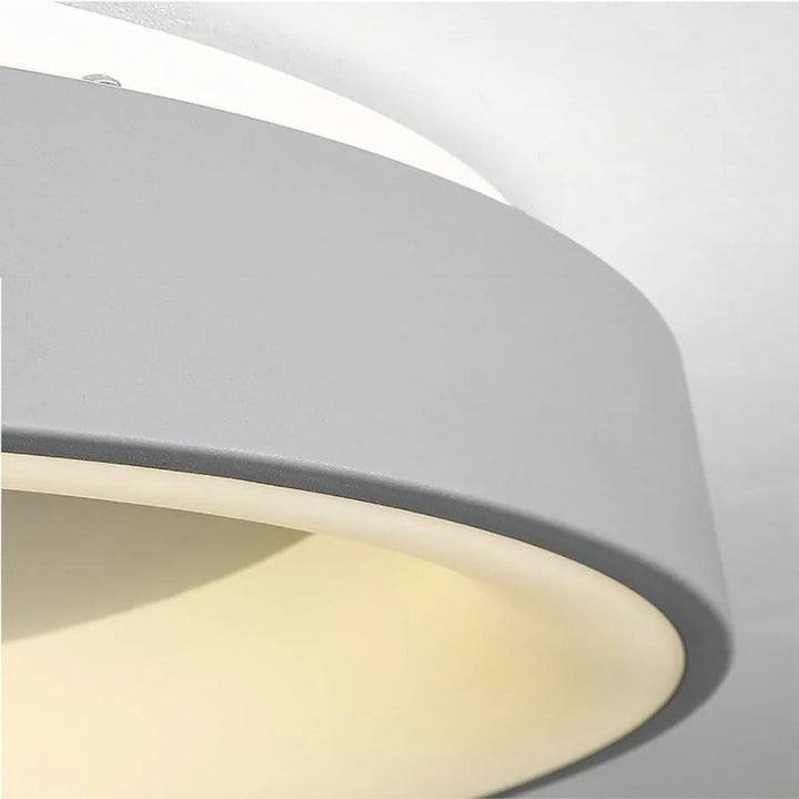 Contemporary circular metal LED ceiling light, sleek design with acrylic finish, emits soft warm or cool lighting for home de