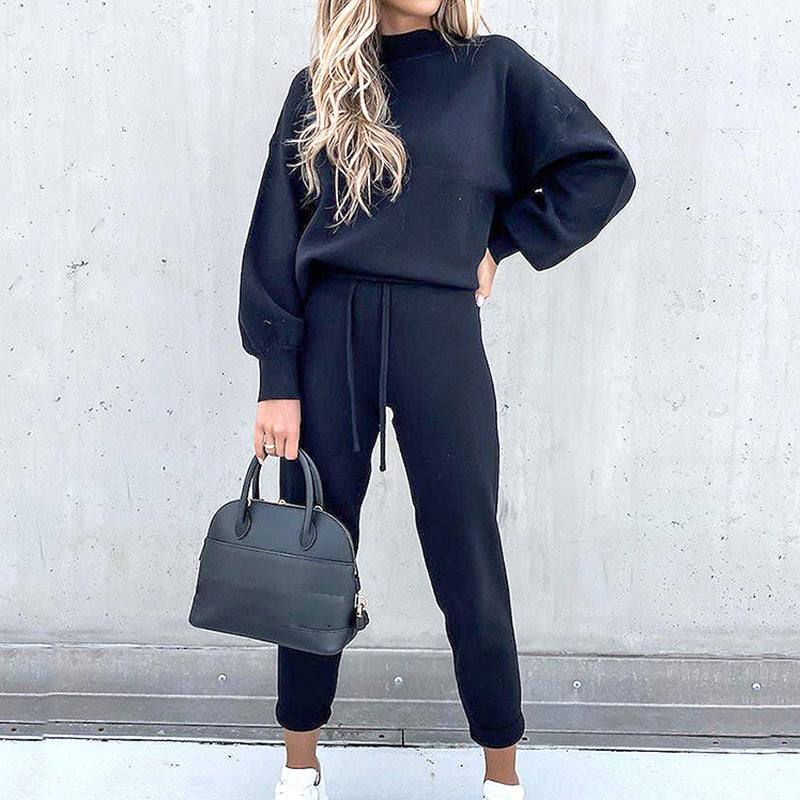 Model wearing a gray women's tracksuit with a relaxed fit sweatshirt and jogger pants for ultimate comfort.