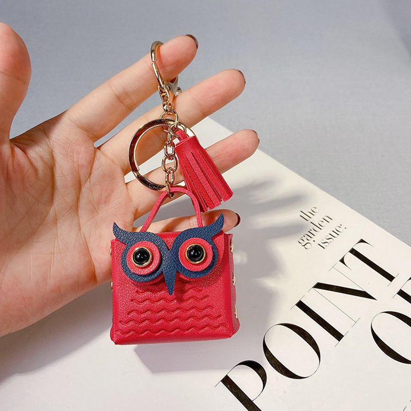 Black mini handbag keychain open, revealing small interior storage space for rings or pills