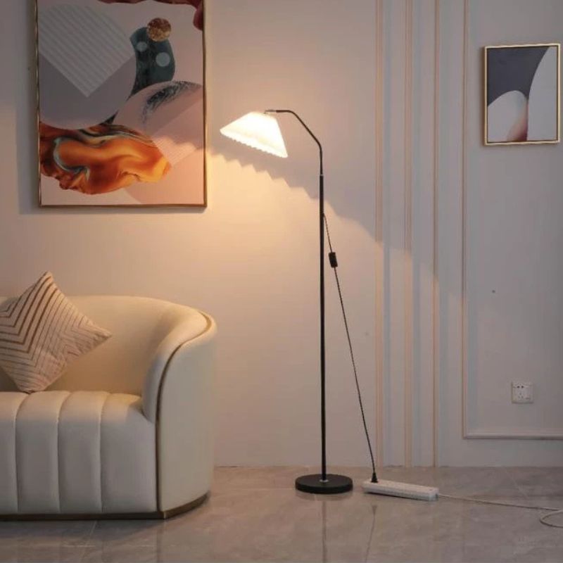Elegant floor lamp with pleated fabric shade, soft warm lighting, crafted from metal, perfect for living rooms or bedrooms.