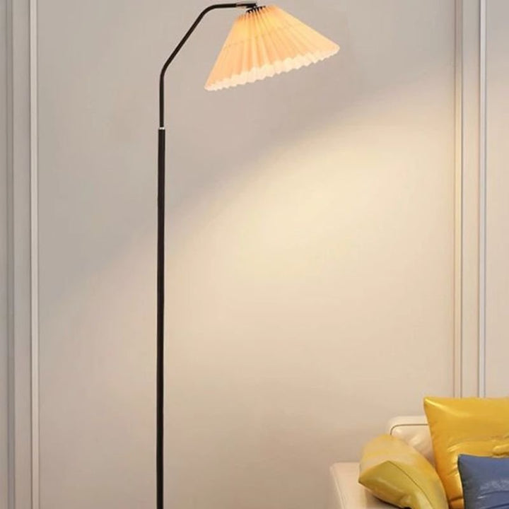 Elegant floor lamp with pleated fabric shade, soft warm lighting, crafted from metal, perfect for living rooms or bedrooms.