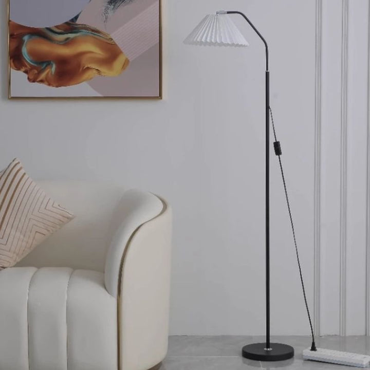 Elegant floor lamp with pleated fabric shade, soft warm lighting, crafted from metal, perfect for living rooms or bedrooms.