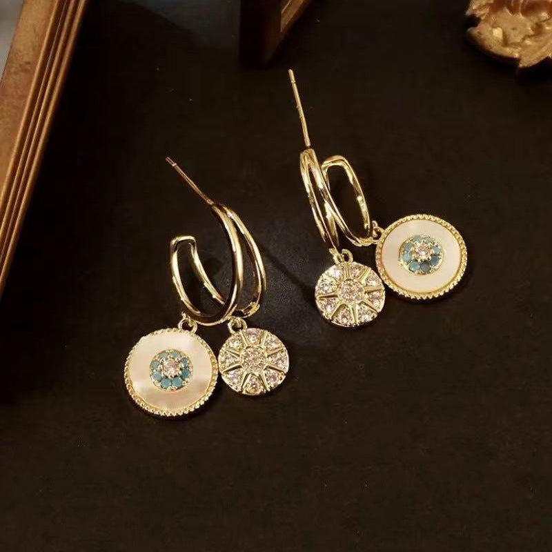 Women's fashion earrings, gold dangle style with an elegant fringe and leaf pattern