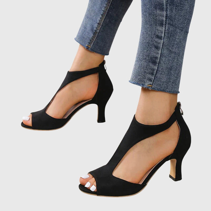 Detailed view of the stiletto heel and multi-strap design on a women's open-toe shoe