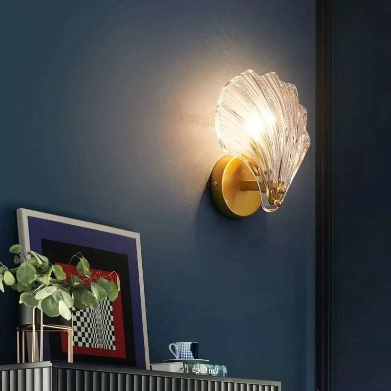 "Elegant shell-shaped glass wall sconce, inspired by coastal design, provides warm ambient lighting for home décor."