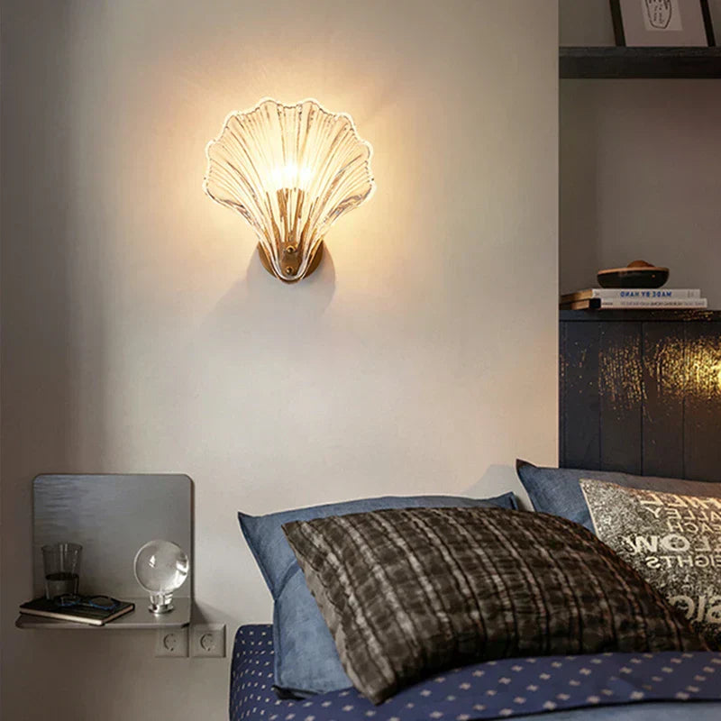 "Elegant shell-shaped glass wall sconce, inspired by coastal design, provides warm ambient lighting for home décor."