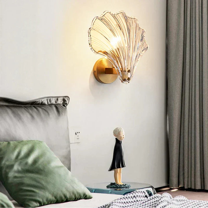 "Elegant shell-shaped glass wall sconce, inspired by coastal design, provides warm ambient lighting for home décor."