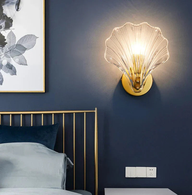 "Elegant shell-shaped glass wall sconce, inspired by coastal design, provides warm ambient lighting for home décor."