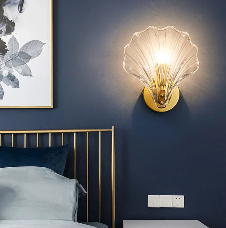 "Elegant shell-shaped glass wall sconce, inspired by coastal design, provides warm ambient lighting for home décor."