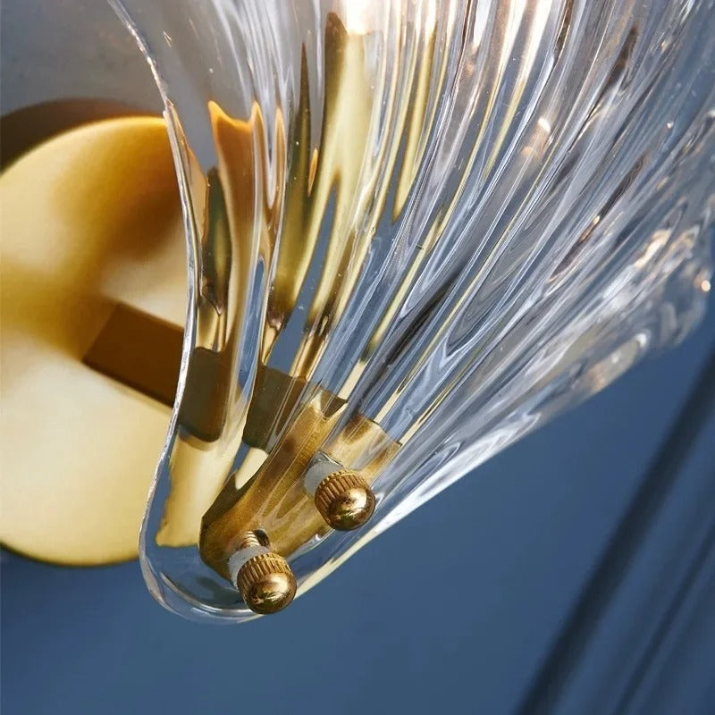 "Elegant shell-shaped glass wall sconce, inspired by coastal design, provides warm ambient lighting for home décor."