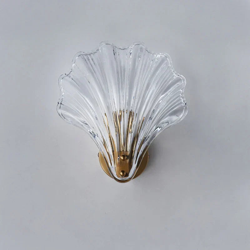 "Elegant shell-shaped glass wall sconce, inspired by coastal design, provides warm ambient lighting for home décor."