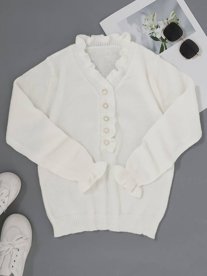 Close-up of a women's blouse showcasing delicate ruffles and intricate decorative buttons.