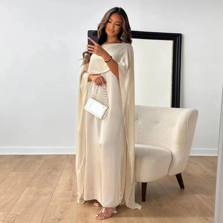 Elegant women's cape maxi dress, perfect for a wedding guest or formal event, in a flowing silhouette.