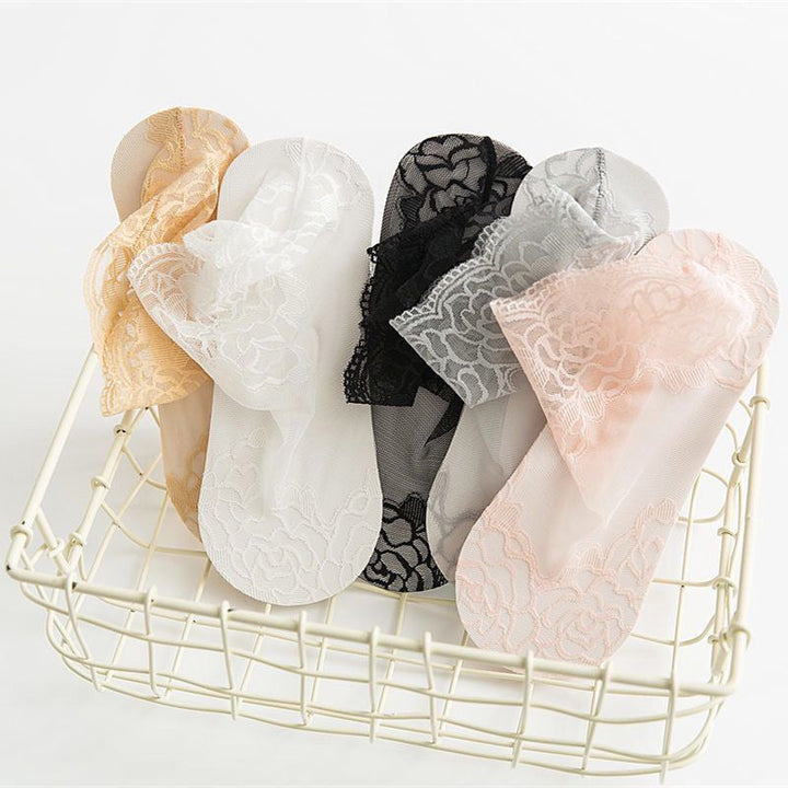 Close-up of a single elegant white lace mesh ankle sock, showing intricate floral detail.