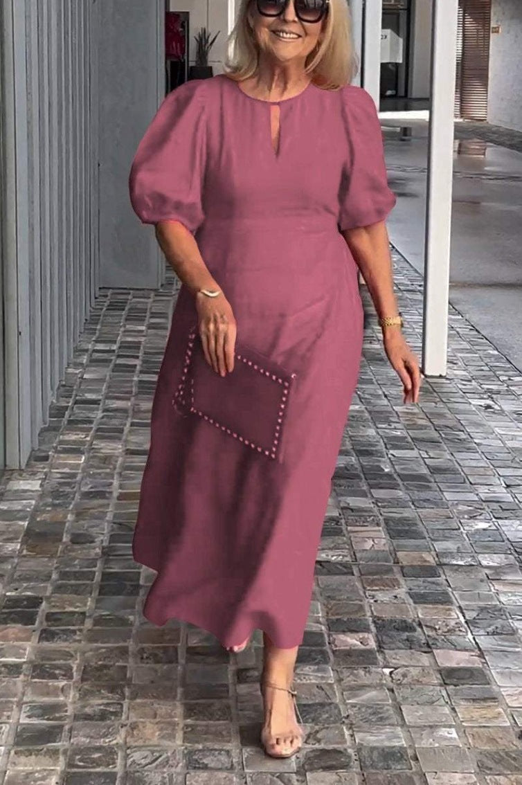 Close-up of the keyhole neckline and puff sleeves on an elegant women's A-line midi dress.
