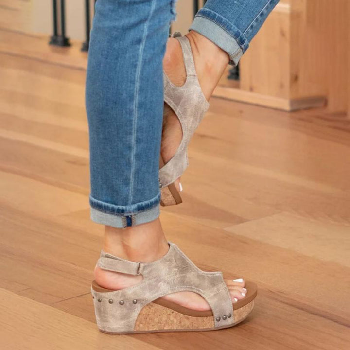 Fashionable women's black wedge sandals featuring a secure ankle strap, ideal for casual and elegant spring outfits.