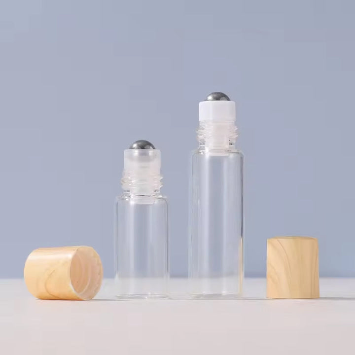 Hand holding a single essential oil roller bottle with a stainless steel ball, ready for aromatherapy application