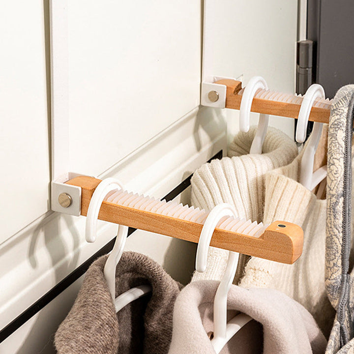 Lifestyle shot of a foldable wood and metal door hook holding a jacket, entryway storage.