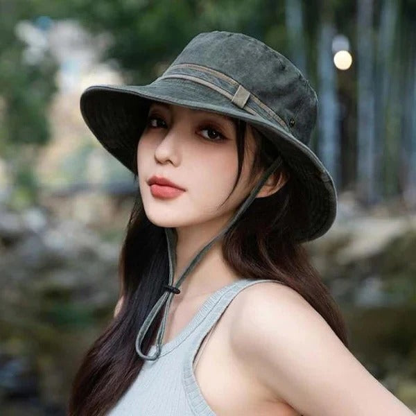 Vented green unisex bucket hat with adjustable chin strap, ideal for outdoor sun protection & travel.