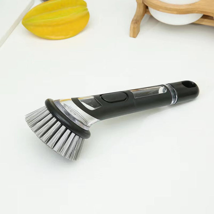 Soap dispensing dish brush, essential household cleaning tool for sparkling clean kitchenware.
