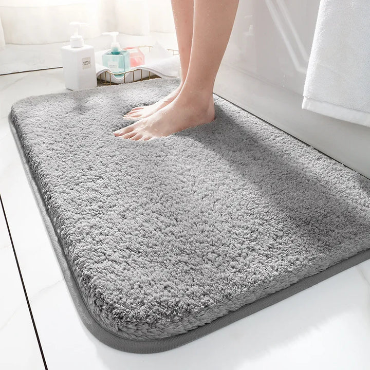 "Luxurious plush microfiber bath rug with non-slip backing, beige color, offers ultimate softness and superior absorbency."