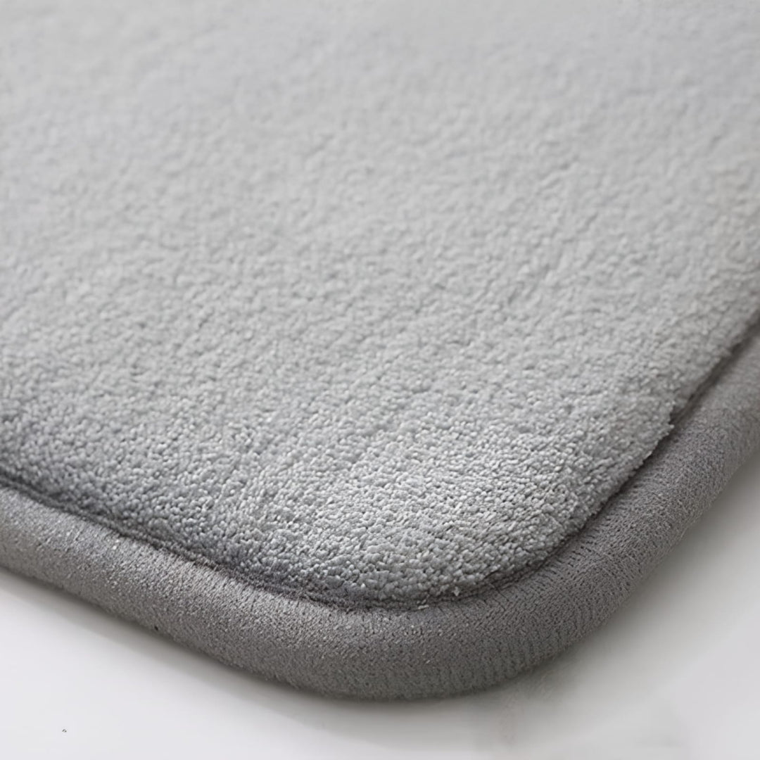 "Luxurious velvet bath mat with memory foam, anti-slip backing, plush coral surface, available in assorted colors and sizes."
