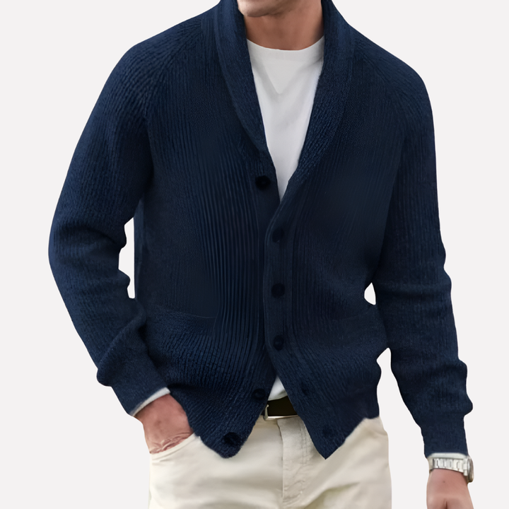 Close-up of men's black knit cardigan: shawl collar, button front & texture of patch pockets. Quality men's knitwear.