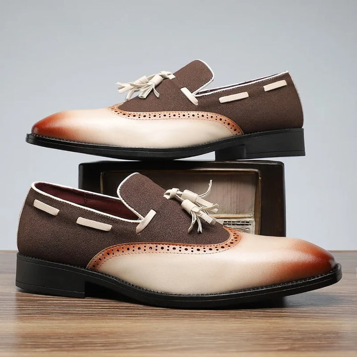 Top-down view of men's formal black tassel loafers with sophisticated brogue detailing.