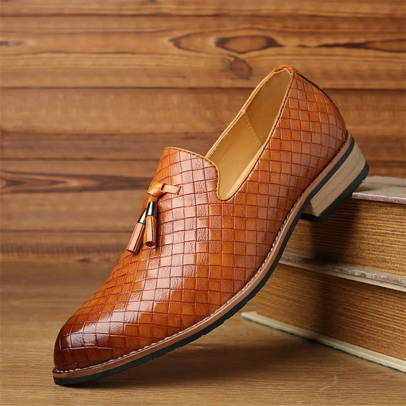 Men's fashion footwear: textured black tassel loafers on a light background, versatile style