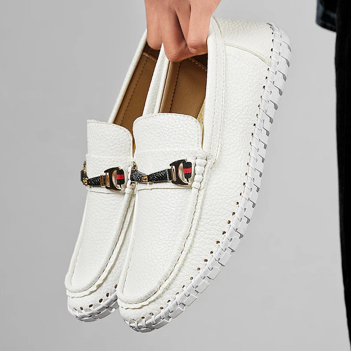 Men's navy blue leather bit loafers on a carpeted surface, offering comfort and refined style