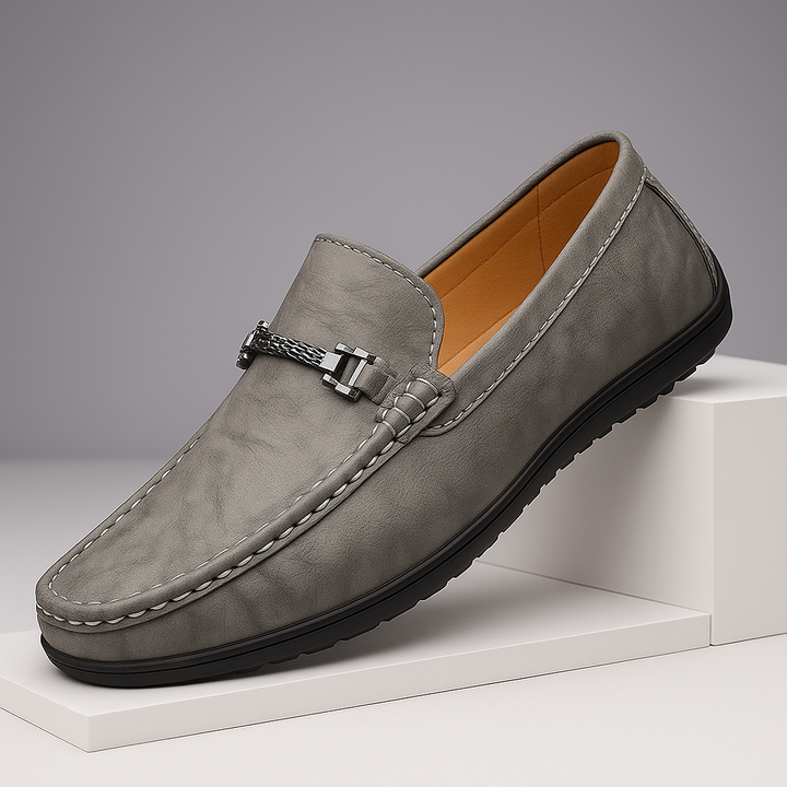 Pair of men's elegant black leather bit loafers on a hardwood floor