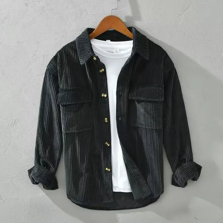 Close-up of ribbed corduroy fabric on a men's button down overshirt in olive green