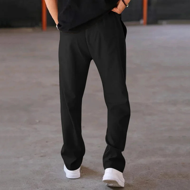 Front view of men's loose-fit formal trousers, showcasing pleats and a relaxed silhouette.