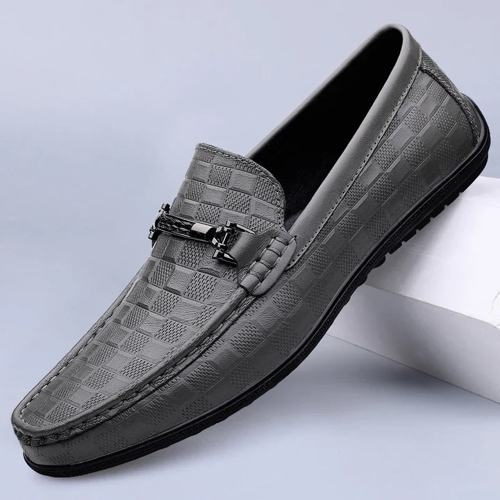 Close-up of the polished leather and metal bit detail on men's premium loafers.
