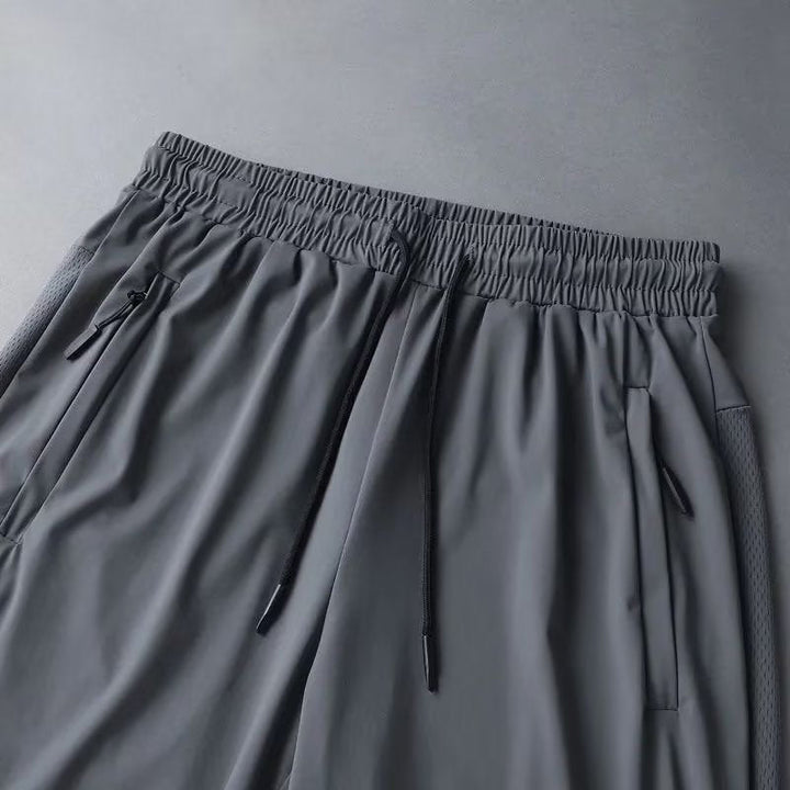 Stack of folded men's athletic shorts in multiple colors, showcasing versatility in sportswear.