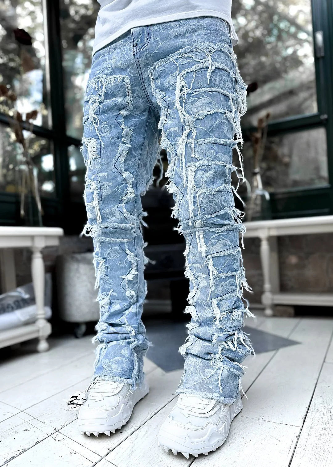 Men's slim fit distressed ripped blue jeans for urban street style. Modern, edgy casual denim pants.